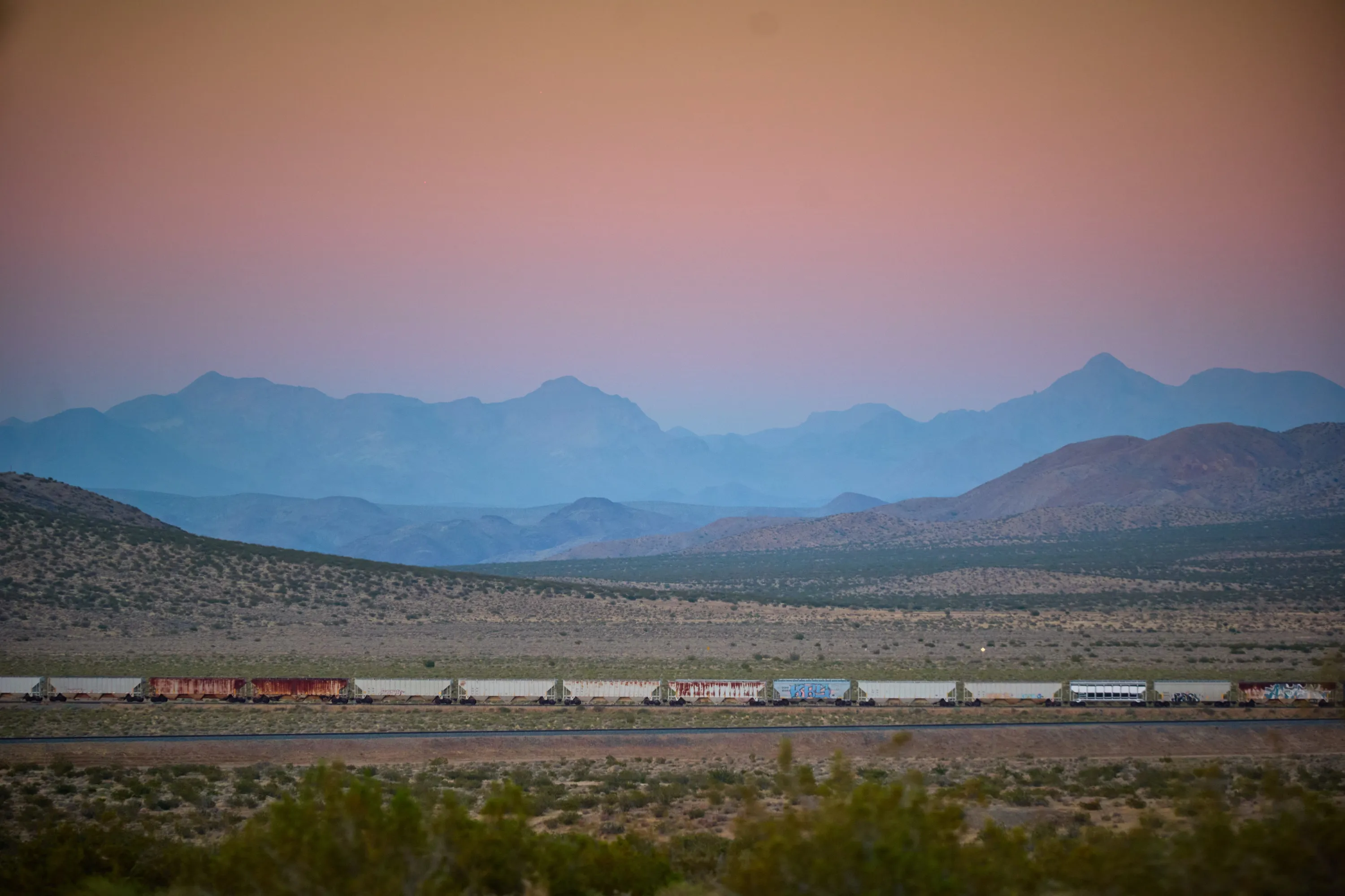 Dawn over the desert, a freight train crossing the basin