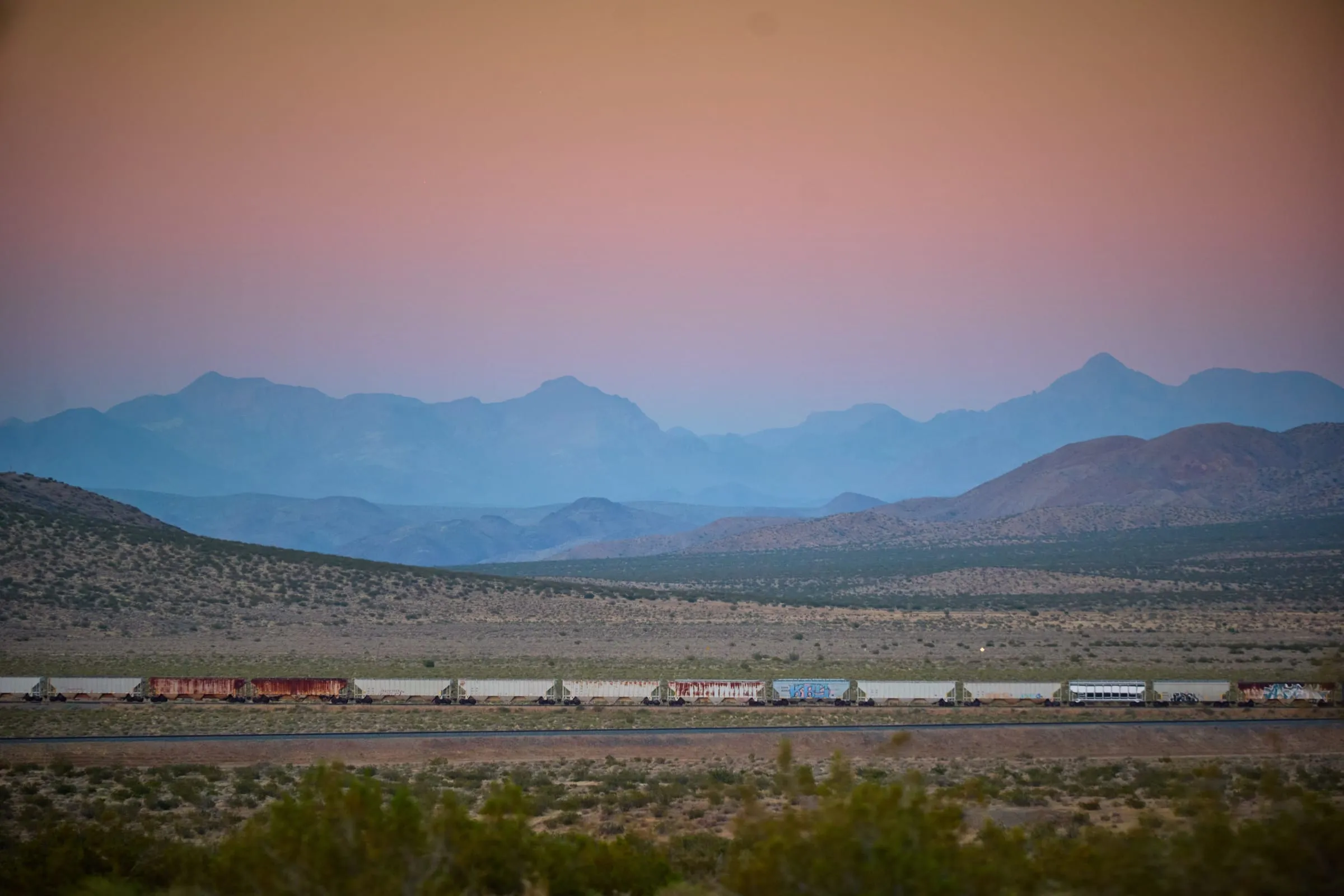 Dawn over the desert, a freight train crossing the basin